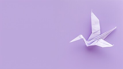 White origami crane on light purple background