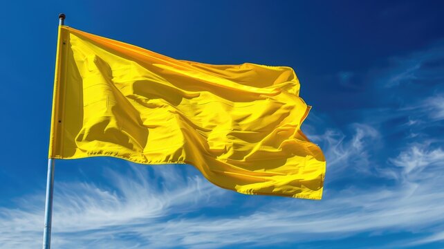 Bright yellow flag waving against blue sky