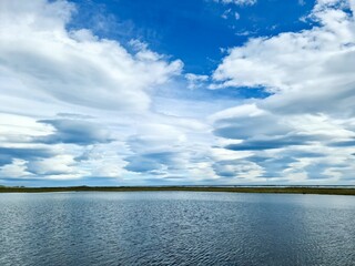 View of a beautiful lake with spectacular clouds and mountains in the Icelandic landscape.