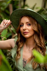 a portrait of a beautiful girl in the rainforest, l with natural make-up and wet hair stands in the jungle among exotic plants.