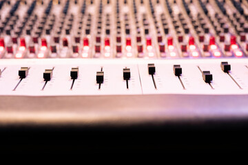 Control panel board desk with sliders and motorized faders in professional recording studio, mixing...