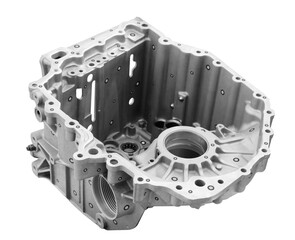 A metal engine block with a lot of holes and a lot of detail. The block is white and silver on a...
