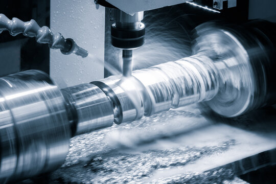 A machine is grinding a piece of metal. The grinding process is creating a lot of dust and debris