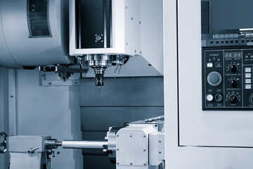 A machine with a drill bit in it. The machine is white and silver