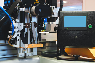 A welding machine with a screen on it is in a room. The machine is black and white