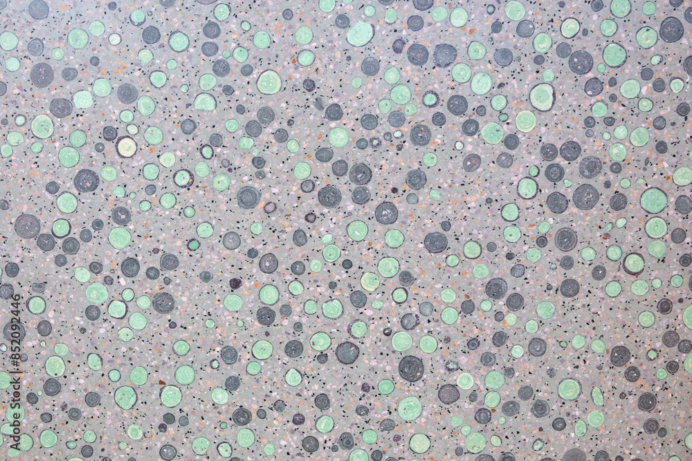 Aufkleber A grey and green background with many small circles. The circles are of different sizes and colors. The background is a mix of grey and green, with some areas being darker and others lighter