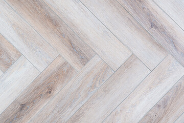 A wooden floor with a checkered pattern. The floor is made of wood and has a light color. The...