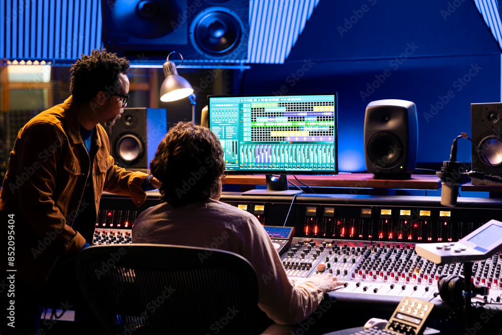 Leinwandbilder singer and producer work on soundboard controller at recording studio station. sound engineer uses d