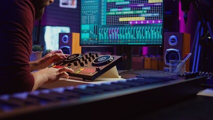 Sound engineer mixing and mastering sounds with electronic audio console, pressing controls and pre...