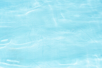 Obraz premium Blue water with ripples on the surface. Defocus blurred transparent blue colored clear calm water surface texture with splashes and bubbles. Water waves with shining pattern texture background.