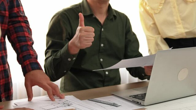 Safety engineer praising skilled architect success design building blueprint project on laptop with architectural document and measurement tool scatter around at modern office. Closeup. Delineation.