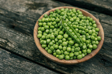 Green Peas. Green background. Green pea top view copy space. Fresh organic green peas. Vegetable harvesting. Beautiful close up of fresh peas and pea pods. Healthy vegetarian food