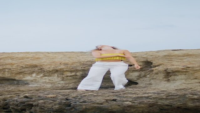 Dance artist moving body sensually on rocks summer day vertical. Girl dancing 