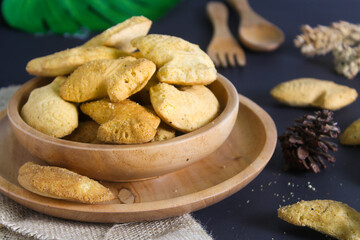 fish-shaped bahulu cake in a wooden bowl.  similar to a madeleine cake but in the shape of a fish
