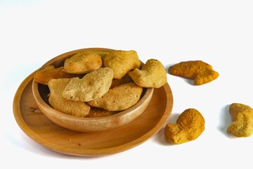fish-shaped bahulu cake in a wooden bowl.  similar to a madeleine cake but in the shape of a fish