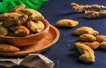 fish-shaped bahulu cake in a wooden bowl.  similar to a madeleine cake but in the shape of a fish