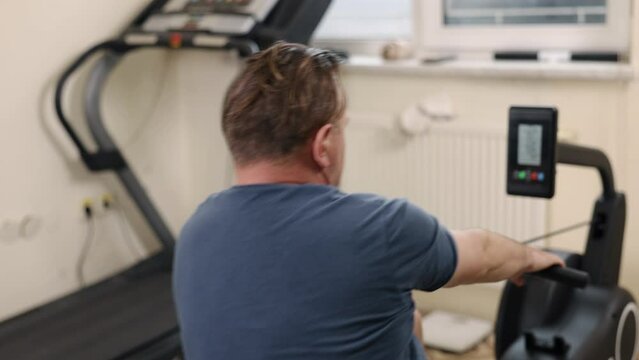 artificial limb, Prosthetic exercise, Gym fitness. Man with prosthetic leg is engaging in exercise on rowing machine inside gym.