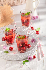 Homemade and tasty lemonade with mint and sweet cherries.
