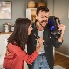 Woman hold microphone and sing, man hold loudspeaker karaoke party