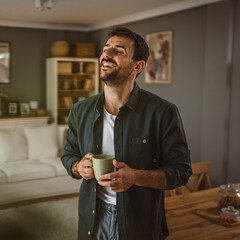 Portrait of adult handsome man drink first coffee in the living room