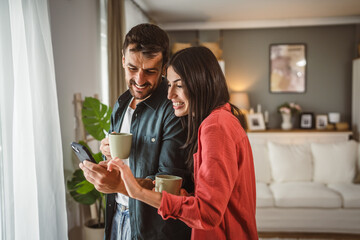 Couple use mobile phone for text message or browse internet at home