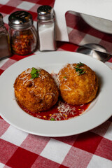 Crispy Arancini with Marinara Sauce on Checkered Tablecloth