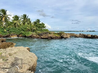 view of a rocky seaside of guadeloupe in the french west indies with waves breaking on rocks and...