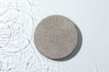 Presentation for product. Stone podium in water on white background, top view