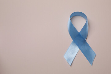 International Psoriasis Day. Light blue ribbon as symbol of support on beige background, top view. Space for text