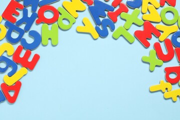 Learning alphabet. Magnetic letters on light blue background, flat lay. Space for text
