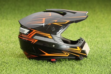 Modern motorcycle helmet with visor on green grass