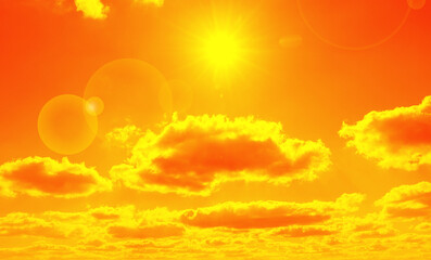Orange sky with sun and clouds during hot summer weather