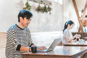 カフェ・喫茶店でテレワーク・リモートワークするアジア人男性（ノマドワーカー）  © buritora