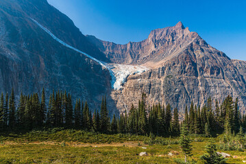 Incredible nature views at Edith Cavell glacier in Jasper Banff National Park in Canadian Rockies during summer time with stunning glacial lake and ice chunks covering the rocky mountain terrain land