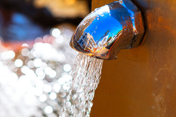 Flowing water for drink from fountain outdoors. Street tap with fresh water