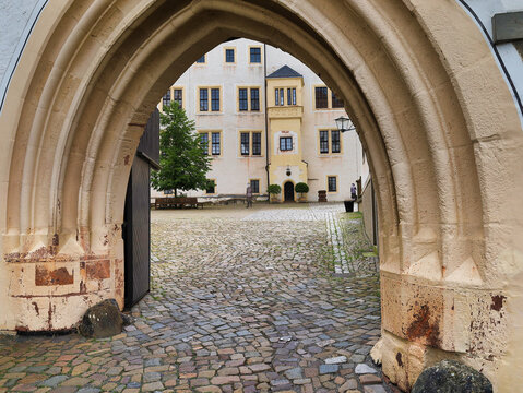 Symmetrischer Blick durch ein gotisches Spitzbogenportal in den Innenhof von Schloss Colditz am 31. Mai 2024, Colditz, Sachsen, Deutschland
