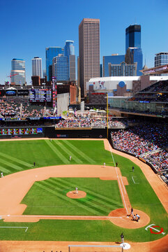 A large crowd gathers at Target Field to root for the Minnesota Twins baseball team at a stadium with a view of the Minneapolis skyline