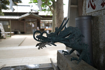 A bronze statue of a dragon spitting water at the Chozuya (purification fountain)