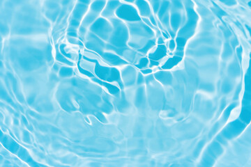 Blue water with ripples on the surface. Defocus blurred transparent blue colored clear calm water surface texture with splashes and bubbles. Water waves with shining pattern texture background.