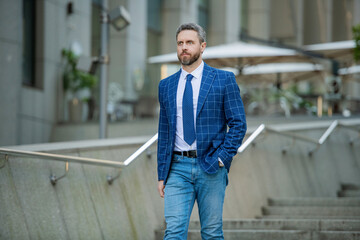 Fototapeta premium Businessman walking in city. Businessman in suit. Mature businessman outdoor. Business boss man. Wall street success. Successful business. Success of entrepreneur. Office manager man. Close a deal
