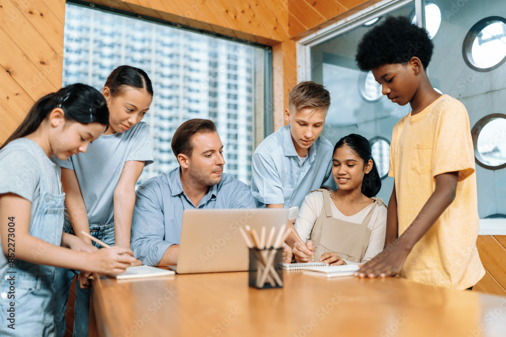 Poster during a lecture course teacher sitting and use laptop. students standing and separate to two group 