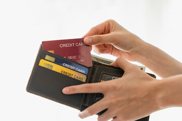 Hand holding wallet and money with credit card in bag.