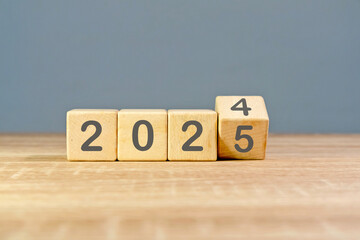 Wooden block with 2024 change to 2025. Turn of the new year. New year's resolution.