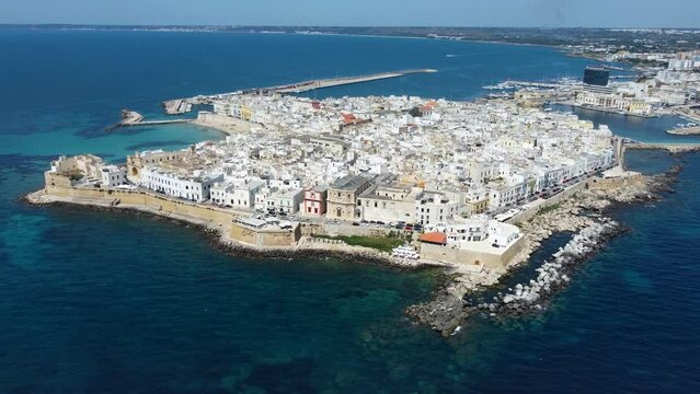Aerial 4K footage of  Gallipoli showing the old town with it's fort, ramparts and harbor, located in Lecce province, Salento peninsula, Puglia, southern Italy