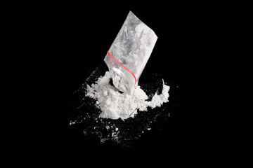 Cocaine in plastic package sprinkled on black background. Illustration of illegal drug substances,...