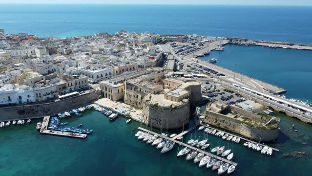 Aerial 4K footage of  Gallipoli showing the old town with it's fort, ramparts and harbor, located in Lecce province, Salento peninsula, Puglia, southern Italy