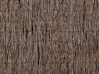 Fototapeta premium Privacy fence with natural dark brown heather branches and sticks for house walls, gardens and plot division texture or background. Rustic natural screening brushwood panels.