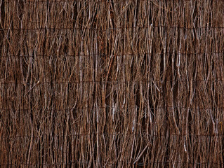 Privacy fence with natural dark brown heather branches and sticks for house walls, gardens and plot division texture or background. Rustic natural screening brushwood panels.