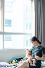 Office women playing with infant baby boy in cozy room