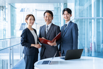 社内に立つ3人のビジネスマン